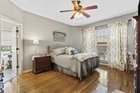 Primary Bedroom Located On Main Level With Hardwood Flooring