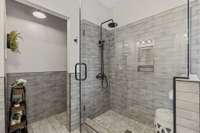 Large Walk In Tile Shower Located In Primary Bedroom