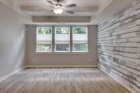 Large primary bedroom on the main level with accent wall, custom ceiling and privacy blinds!