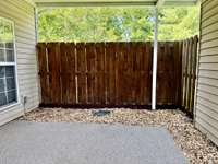 Fenced Private covered patio with covered 2 car carport and another storage closet