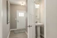 Front door entry with powder room away from living and kitchen area.