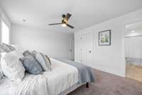 Primary suite upstairs features ceiling fan, full bathroom and walk-in closet