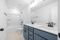 Dual vanities in primary suite with custom cabinets and quartz countertops