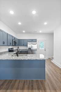 Big spacious kitchen with breakfast bar, lots of custom craftsman cabinets with shaker style doors and soft close drawers, stainless steel appliances and granite counters.