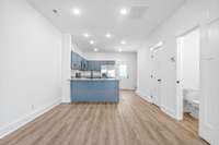 Dining area with LVP flooring opens to kitchen with breakfast bar
