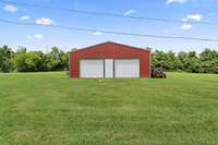 30x30 workshop with concrete floors, double roll-up doors, and new lighting.