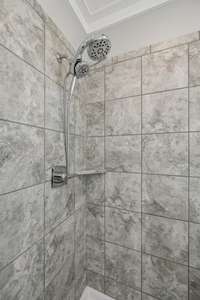 Upgraded shower head in Tile surround walk in shower