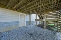 Access under the deck to the walkable crawlspace which has a decked area for storage or workshop