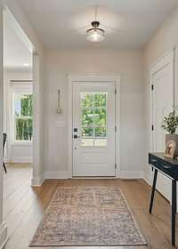 Sun drenched front entrance and foyer welcome family and guests.