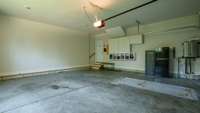 What a tidy garage!  There are some cabinets and cubbies for storage.  The tankless water heater is located in the far right corner of the garage.