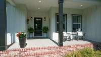 A covered front porch large enough for chairs welcomes guests to your home.