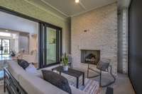 The Covered Porch with a beautiful fireplace and retractable sliding doors to entire the home for indoor/outdoor living