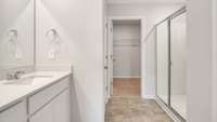 THE PRIMARY BATHROOM FEATURES A SPACIOUS WALK-IN SHOWER, DOUBLE VANITY WITH QUARTZ COUNTERTOPS, AND DIRECT ACCESS TO YOUR LARGE WALK-IN CLOSET