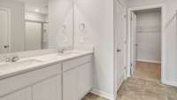 THE PRIMARY BATHROOM FEATURES A SPACIOUS WALK-IN SHOWER, DOUBLE VANITY WITH QUARTZ COUNTERTOPS, AND DIRECT ACCESS TO YOUR LARGE WALK-IN CLOSET