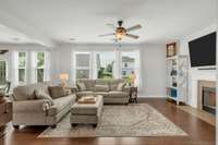 Hardwood Living Room with Woodburning Fireplace and Ceiling Fan
