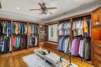 Incredible primary suite closet the size of a room, with an additional wardrobe hallway closet with built-in cabinets and drawers