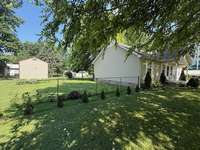 Showing the left side of the fenced in back yard. It is a very well kept yard.