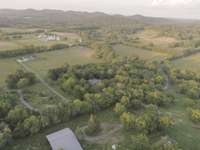 Look at how the house is perfectly snuggled on the front 5.01 acreage of mature tree scapes offering quiet tranquility while the rear 5.49 acreage offers quick access to the front acres while featuring open fields of green