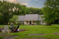 Lush green landscaping set perfectly within a mature treeline and open pasture