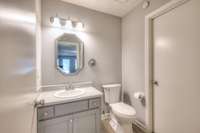 Sophisticated, freshly updated half-bathroom with modern fixtures, clean lines, and an octagonal mirror, adding a touch of elegance. Its neutral color scheme and design enhance the overall contemporary feel of the home.