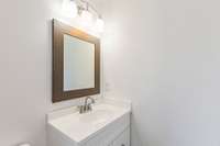 Full bathroom off of hallway between Bedrooms 2 and 3. Updated vanity, hardware, lighting, and mirror.