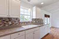 Views to the backyard over the kitchen sink. Recessed lighting, lots of countertop space, tons of cabinet storage. Porcelain double sink.