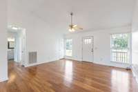 Large Living Room with vaulted ceilings, fresh paint, gleaming LVP floors, and open-concept floorplan.