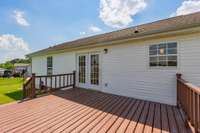 Expansive back porch for gathering! Opens to concrete patio and firepit area, and large, level backyard.