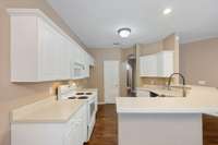 The kitchen has white cabinets and nice counter space.