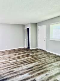 Looking from the hallway, back into the living room and the door to the balcony.