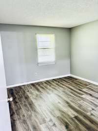 Here's another picture of the bedroom with slightly different lighting, showing the texture of the flooring, as well as the light gray walls.