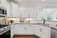 White cabinetry makes your custom granite countertops pop with tile backsplash and cabinet underlighting