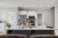 Large kitchen with granite counters, island sink and bar, stainless steel appliances and breakfast room.