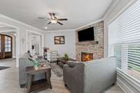 The living room is highlighted by a beautiful stone fireplace with a wood mantel