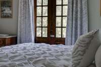 The Primary Bedroom up stairs has Charming Inward-Swing French Doors the open to a beautiful view of the front grounds.
