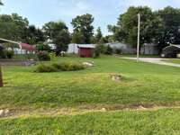 Level backyard with the storage building to remain.