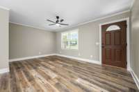 Double window overlooking the front yard, ceiling fan and crown molding trim.