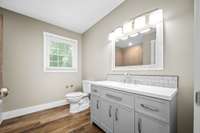 New vanity, new hardware, new lighting, new toilet, window overlooking the front yard.