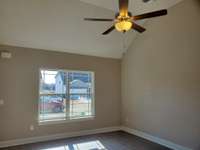 Spacious Living Room with Vaulted Ceiling and Ceiling Fan.  Similar Home is pictured.