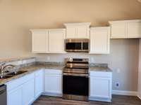 Stainless Smooth Top Stove, Microwave and Dishwasher are provided.  Picture of Similar House.
