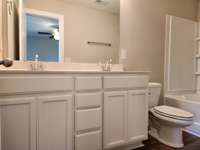 Primary Bathroom has White or Brown Cabinets and Double Sinks.  Picture of Similar House.