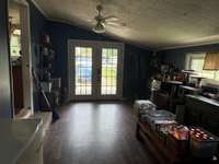 View of den from utility room. Kitchen door to the left, French doors ahead open to front of house