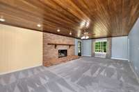 Living Room- carpet, fireplace with gas logs, wood ceiling, ceiling fan, crown molding, recessed lighting