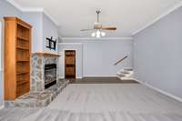 Den - carpet, crown molding, ceiling fan, fireplace with gas logs, built in shelves