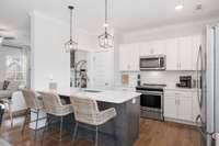 Stylish light fixtures and a sparkling kitchen are sure to make the family chef happy!