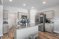 Hallway behing kitchen has a 1/2 bath, closet, drop zone & garage.