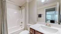 The upstairs bath has crown molding, tile floor, and a vanity with a quartz countertop and a rectangular sink.
