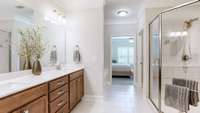 The primary bath features crown molding, tile floor, double vanity with quartz counters and rectangular sinks, a large tile shower with a bench, and a soaking tub.