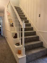 Stairs to upper area bedroom with a full bath and storage