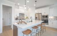 ***Photo taken from the Furman model home in Durham Farms***  Your gourmet Kitchen includes "Quill" colored cabinetry with soft close doors and roll-out trays, quartz countertops, under cabinet lighting and built-in appliances.